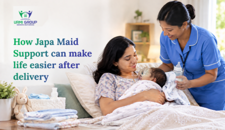 Mother cradles her newborn while a caregiver in blue uniform offers support in a cozy bedroom; text promotes post-delivery Japa maid services.